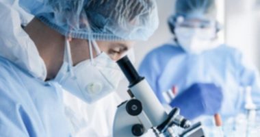 Image of a researcher looking through a microscope